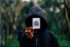 Poker Man in hoodie holding card